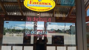 Carlsbad Caverns National Park storefront with handwritten hours on glass for a nearby restaurant.