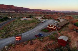 Desert lodge along the road at Capitol Reef National Park, with red rock mesas and a rustic building.