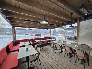 Cafe patio at Black Canyon Of The Gunnison National Park with wooden deck, red bench seating, and outdoor tables.