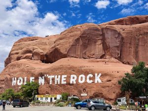 Hole N' The Rock gift shop and giant sandstone sculpture at Canyonlands National Park, with a bright blue sky above.