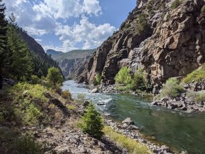 Pine Creek Trailhead along the Gunnison River in Black Canyon of the Gunnison National Park, with towering canyon walls.