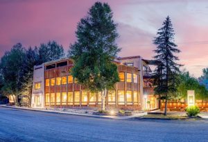 Lodge exterior at Black Canyon Of The Gunnison National Park, warm interior lights glowing through large windows.
