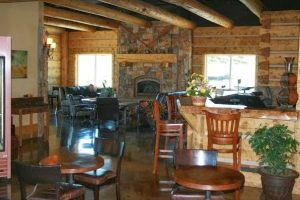 Interior of a rustic lodge cafe with a stone fireplace and wooden beams in Black Canyon of the Gunnison National Park
