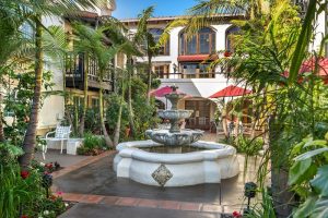 Courtyard fountain at lodging near Channel Islands National Park, surrounded by tropical palms and seating areas.