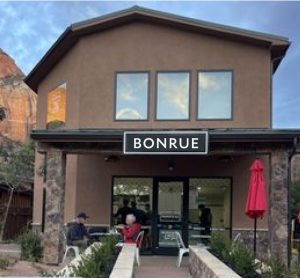 Rustic bakery storefront in Zion National Park with a brown stucco exterior and large windows.