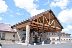 Capitol Reef National Park lodge exterior with a stone and timber porte-cochere, set against a bright blue sky.