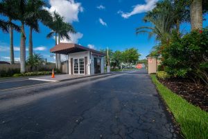 Guardhouse and entrance to the Goldcoaster lodging area in Biscayne National Park, framed by palm trees and a bright blue sky.