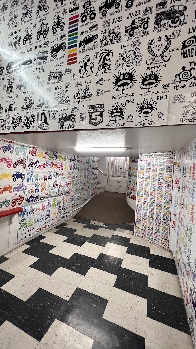 Inside Arches National Park gift shop: walls covered with black-and-white sticker art, colorful decals, and a black-and-white checkered floor.
