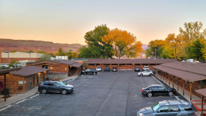 Lodging parking area at Canyonlands National Park near Moab with timber buildings and autumn trees.