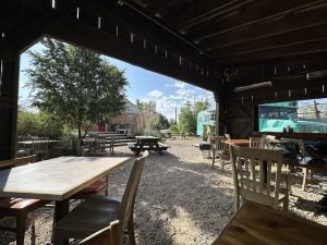 Outdoor dining area at Magnolia's Kitchen in Capitol Reef National Park, featuring wooden tables under a shaded shelter.