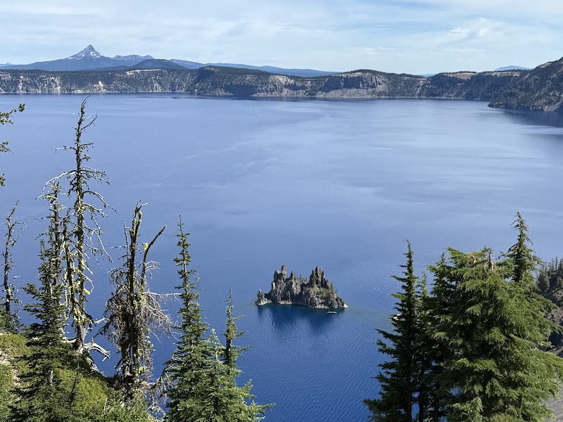 Phantom Ship Overlook, Crater Lake National Park, shows the Phantom Ship rock formation rising from the deep blue Caldera lake with surrounding cliffs.