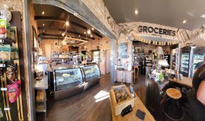 Rustic cafe and groceries interior in Capitol Reef National Park, featuring brick walls, warm lighting, and refrigerated display cases.