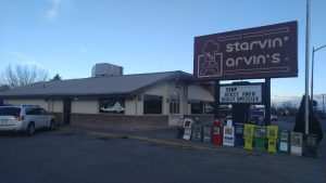 Exterior view of a casual restaurant near Black Canyon Of The Gunnison National Park, with a large sign and row of newspaper boxes outside.
