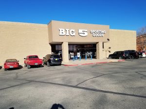 Carlsbad Caverns National Park gift shop exterior near the visitor entrance, with parked cars and a clear blue sky.