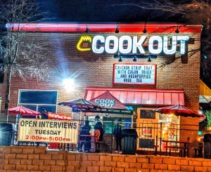 Evening view of a neon-lit fast-food restaurant exterior beside Congaree National Park in a nearby town.