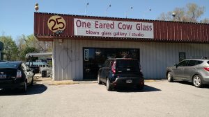Gift shop storefront in Congaree National Park, showing a metal building and cars in the lot.