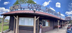 Rustic cafe and motel building along a Bryce Canyon National Park roadside complex beneath a bright blue sky.