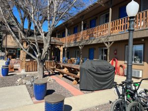 Lodging courtyard with picnic tables, blue doors, and a grill cover outside a lodge in Black Canyon Of The Gunnison National Park