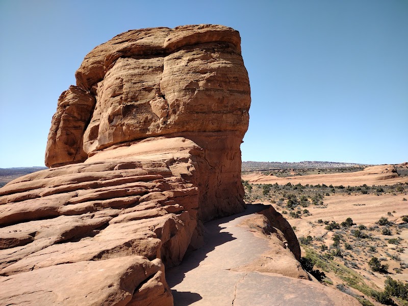 Delicate Arch rises beside a clear blue sky at Arches National Park, a famed sandstone formation.