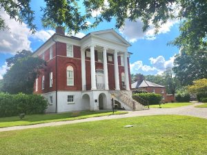 Historic Robert Mills House and Gardens at Congaree National Park, a red brick colonial building with tall white columns and a grand entry staircase.