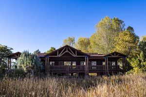 Lodge building at Capitol Reef National Park surrounded by tall grasses and autumn trees.