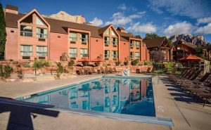 Outdoor pool at lodging in Springdale near Zion National Park, with red buildings and desert landscaping.