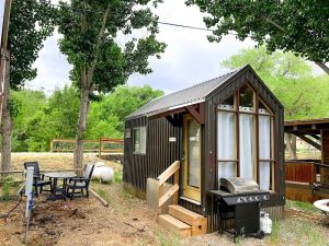 Cedar Creek Cabin exterior at Black Canyon of the Gunnison National Park, a rustic lodging unit with a small deck and grilling area.
