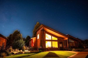 Lodge exterior at Bryce Canyon National Park glows warmly under a star-filled night sky.