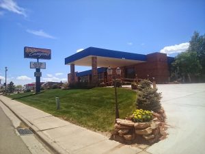 Modern lodge exterior with blue awning and manicured lawn in Canyonlands National Park.