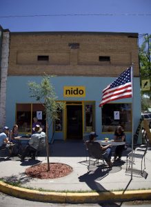 Restaurant exterior in Black Canyon Of The Gunnison National Park, with guests dining at outdoor tables under a bright sky.