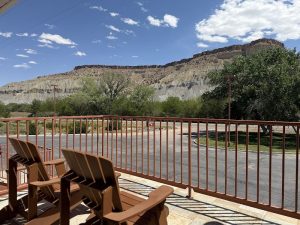 Patio seating at Capitol Reef National Park overlooking Cathedral Valley sandstone cliffs.