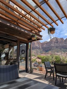 Outdoor cafe patio in Zion National Park offering seating with a canyon view of sandstone cliffs.