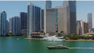 Downtown Miami skyline along Biscayne Bay with teal water, high-rise towers, and a yacht gliding past a waterfront scene, Biscayne National Park.