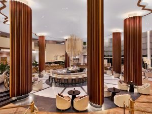 Luxe Eden Roc Miami Beach lobby features a circular bar and tall wooden columns near Biscayne National Park.