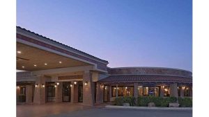 Exterior of a low-rise lodging building at Carlsbad Caverns National Park, lit by warm lamps under a dusky sky.