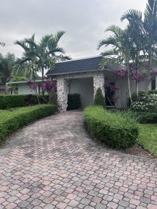 Americana Village Condominium entrance in Biscayne National Park, framed by tropical palms and stone columns.
