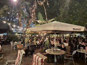 Lagniappe outdoor dining area at Biscayne National Park with string lights and tropical plants, under large umbrellas.