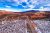Highway winds through red rock fins and snow-dusted desert in Arches National Park near Moab, Utah.