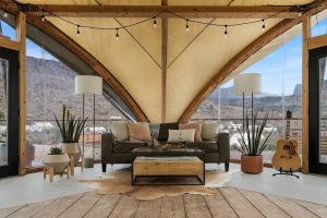 Cozy glamping tent living area with sofa and plants at Under Canvas Zion in Zion National Park.