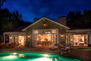 Lodge-style house with a glowing pool area at dusk, set against Channel Islands National Park.