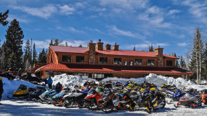 Snow-covered lodge with a line of snowmobiles parked in front in Black Canyon Of The Gunnison National Park.