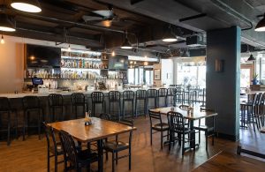 Interior dining area at Congaree National Park with a long bar, high stools, and wooden tables.