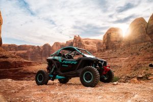 Rugged turquoise-RZR off-road vehicle parked on a rocky desert overlook in Canyonlands National Park, Moab area.