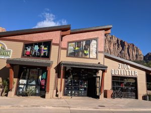 Zion National Park visitor center retail storefront with clothing displays and hiking gear.