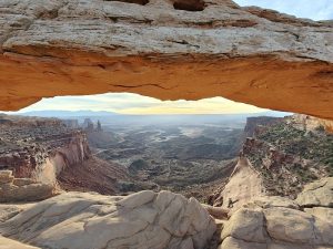 Mesa Arch frames a sweeping canyon panorama in Canyonlands National Park at sunset.