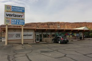 Outpost gift shop near Canyonlands National Park in Utah, featuring Verizon signage, a parking lot, and a low-slung storefront.