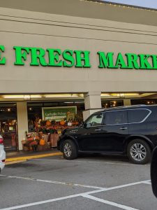 Grocery storefront with a bright green sign in Congaree National Park at the park entrance, with pumpkins displayed outside for autumn.