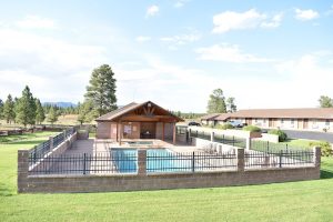 Pool area of a lodge in Bryce Canyon National Park, set on a green lawn with a clubhouse.