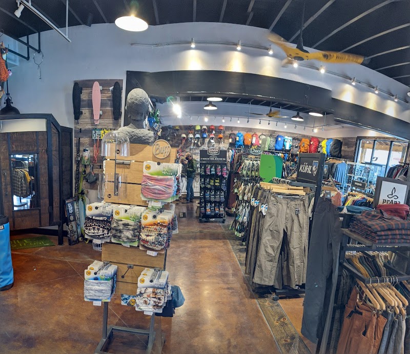 Inside a busy gift shop at Arches National Park, racks of outdoor clothing, backpacks, hats, towels and souvenirs line the space.