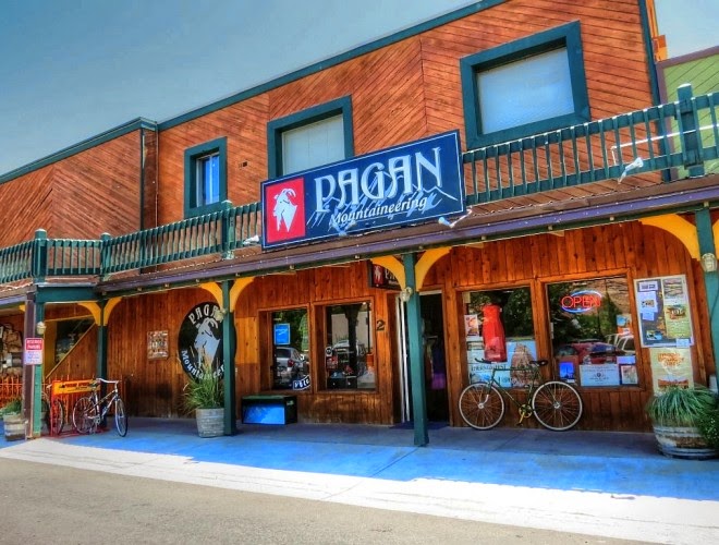 Wooden storefront with orange-brown siding and teal trim, bicycles out front, blue ramp, Arches National Park gift shop exterior.